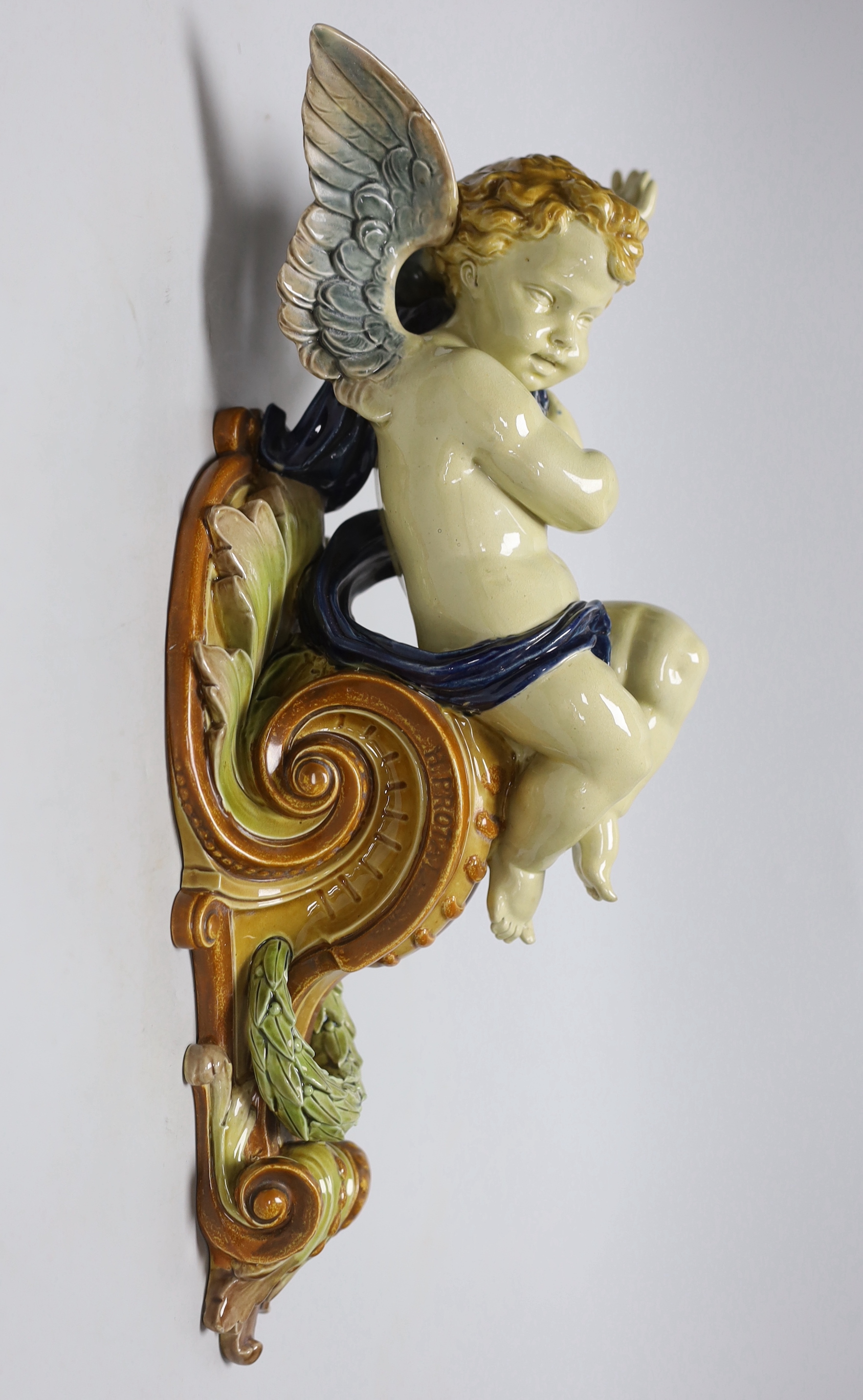 Hughes Protat, a Minton Majolica cherubic wall bracket, incised signature, 42cm high